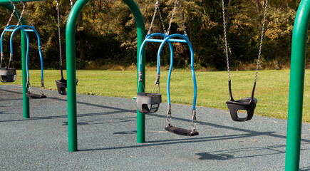 Fototapeta premium Childrens swing set with rubber surface in a park