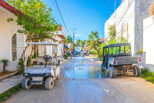 Golf cart buggy cars carts muddy street village Holbox Mexico.