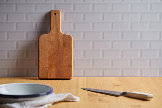 Wooden cutting board on table in domestic kitchen