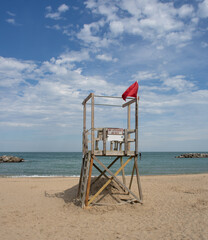 Lifeguard station at a sandy beach on a lake with clouds and blue sky and 