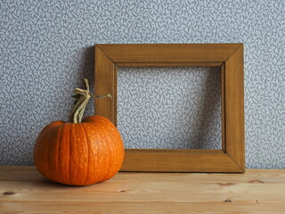 Picture frame and pumpkin decor on the table. Fall season. Place for text  
