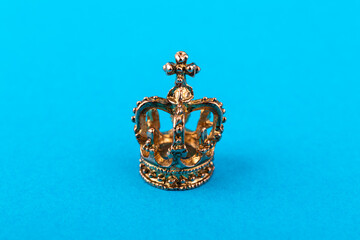 Small golden crown on blue background.