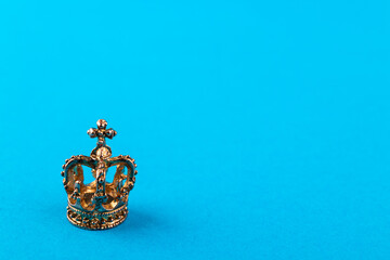 Small golden crown on blue background.
