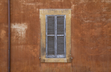 Closed vintage wooden window shutters on an old building in Rome, Italy.