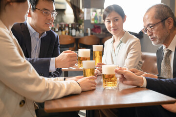 ビールで乾杯する会社帰りの打ち上げ飲み会