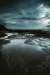 Epic seascape landscape with clouds and flood ground. Black and stormy clouds weather in...