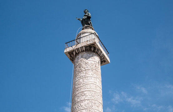 Trajan's Column (Colonna Traiana) with a bronze figure of Saint Peter the Apostle. Roman triumphal column in Trajan Forum, Rome, Italy.