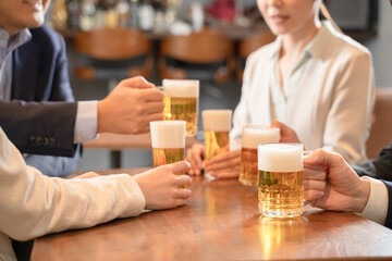 ビールで乾杯する会社帰りの打ち上げ飲み会手元