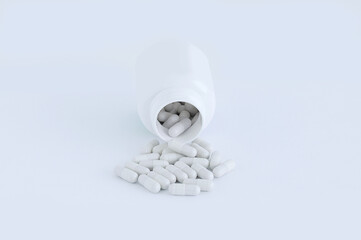 Tablets are white capsules in bulk from jar. White background.