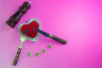 plate with a heart toy, pepper mill , cutlery, concept
