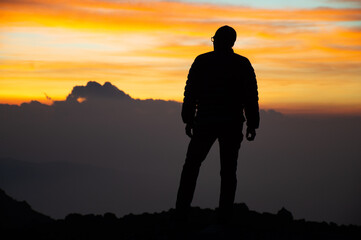 Sillohuete from a person in the mountain enjoying a beautiful sunset in the mountain