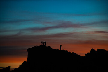 Obraz premium silhouettes on the top of a moutain. Beautiful colors sunset with blues, reds and magentas. 