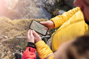 people using gps navigator app, forest hiking, couple on mountain at sunset - obrazy, fototapety, plakaty