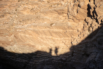shadow of two people on cliff rock