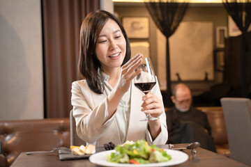 飲食店で赤ワインを飲み口紅の跡を拭く女性