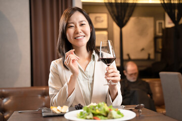 飲食店で赤ワインを飲む女性