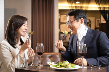 飲食店でマスク会食をする男女