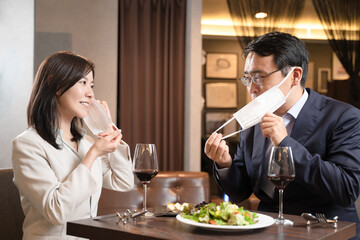 飲食店でマスク会食をする男女