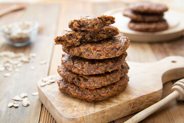Healthy homemade cookie with oat flakes, dried fruits and seeds. Wooden rustic table.