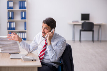 Young male employee sitting at workplace