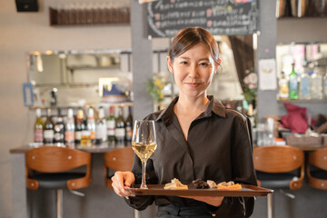 飲食店でワインを提供する女性スタッフ