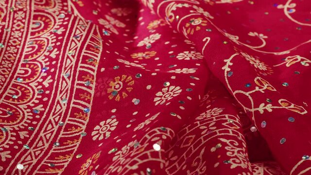 Red indian fabric close-up, arabian design, pattern. Cloth texture background. Macro shooting of textile.