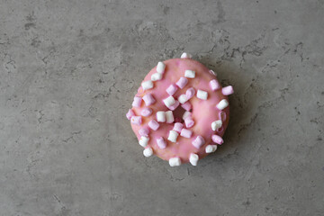 Pink donut on gray concrete background. Healthy and unhealthy food. Choice. Dieting, obesity, eating lifestyle and nutrition concept