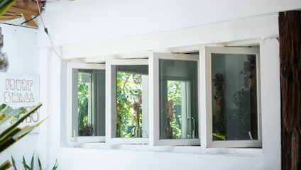 classic windows with white wooden frames. a pretty facade of a coffee shop in a contemporary vintage theme. a well maintained old building for inspo and tourism campaign.
