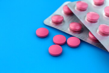 A pile of medicines in the form of pill sizes and lie on a blue background.