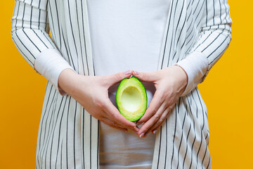 Closeup of Hands of Adult Caucasian Female Holding Split Avocado Fruit As a Demonstration of Female...