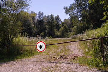 Warning sign beware of ticks in infested area in the forest.