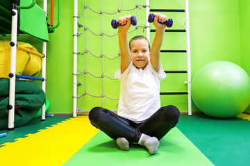 Little girl goes in for sports in special tight clothes in the children's center and leads a healthy lifestyle