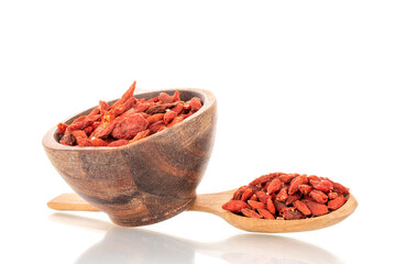 Dried sweet goji berries with wooden cup and wooden spoon, macro, isolated on white.