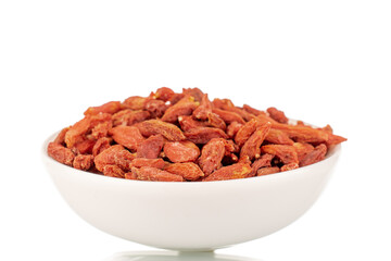 Dried sweet goji berries with white ceramic saucer, macro, isolated on white.
