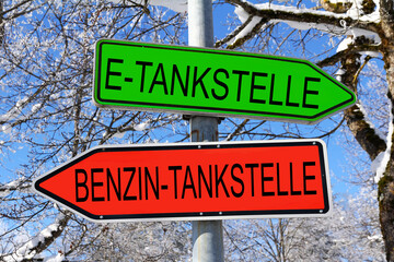 Hinweisschilder in grün zur E-Tankstelle und in rot zur Benzin-Tankstelle