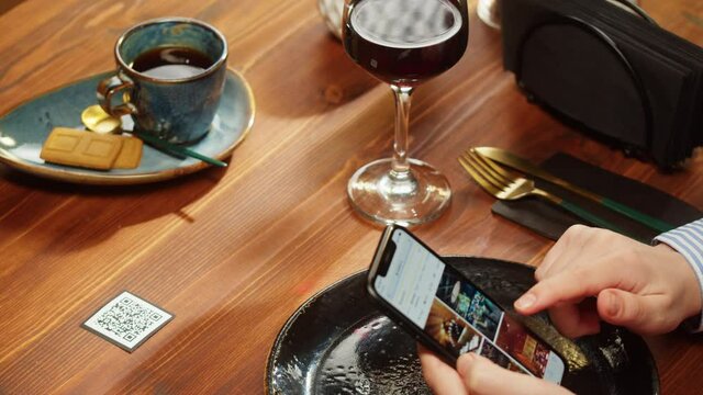 Scanning QR code in restaurant. Woman using qr code with smartphone, online menu in cafe. Modern technology, ordering meal in application. Contactless touch-free payment in app.