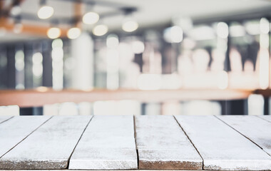 Empty wooden table and blurred background of abstract in front of restaurant or coffee shop for display of product or for montage