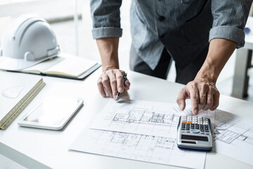 Architect working on blueprint, Engineer working with engineering tools for architectural project on workplace, Construction concept - building project, blueprints, ruler and dividers