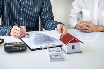 Real estate broker agent being analysis and making the decision a home estate loan to customer to signing contract documents for realty purchase, Bank employees recommend mortgage loan approval