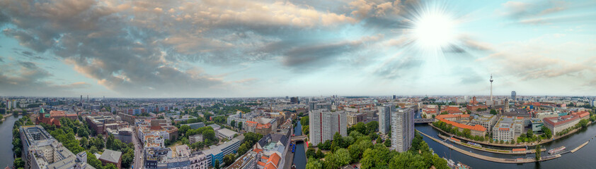 Fototapeta na wymiar Panoramic aerial view of Berlin skyline at sunset with major city landmarks along Spree river, Germany from drone in summer season.