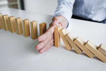 Risk and strategy in business, Close up of business woman hand stopping wooden block between three...