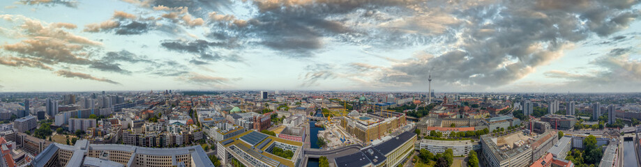 Panoramic aerial view of Berlin skyline at sunset with major city landmarks along Spree river, Germany from drone in summer season.