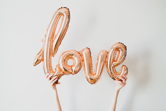 Valentine's Day balloons in shape of Love word in female hands. Romantic, love concept.