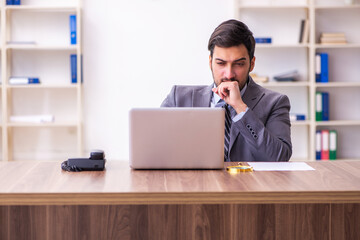 Fototapeta premium Young handsome businessman employee working in the office