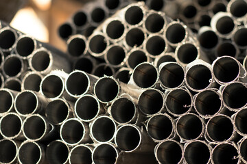 Packages with pipes lie in the workshop in the rays of the sun, with selective focus. 
