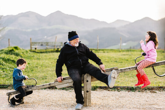Grandfather with kids on seesaw