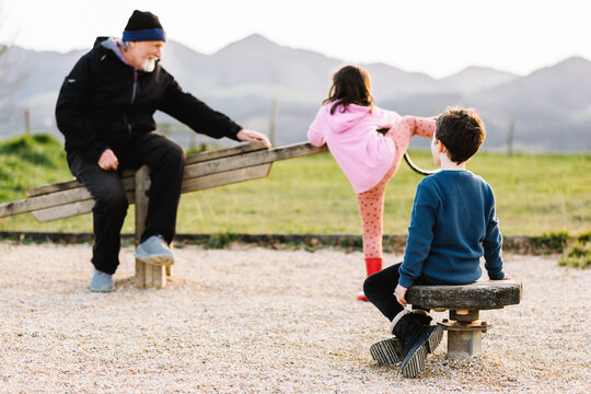 Grandfather with kids on seesaw
