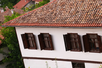 selective focus, old historical stone houses in Safranbolu, the old historical district of Karabük district. red roof tile. Turkish flag hanging in stone house. brown wooden windows.