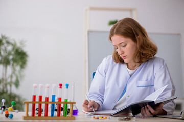 Young female chemist student working at the lab