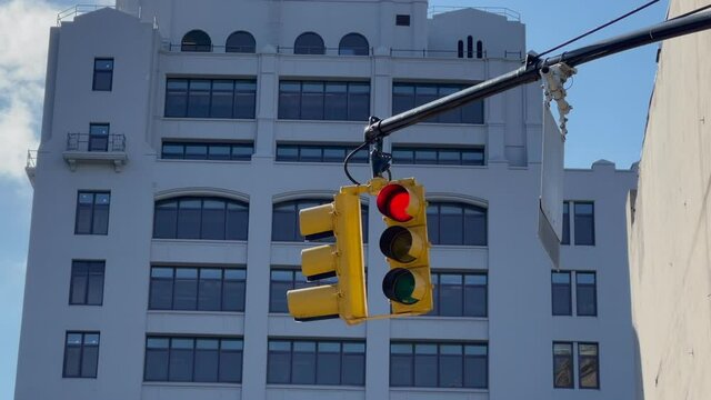 A yellow traffic light hangs at intersection in New York, USA. Red stop signal.